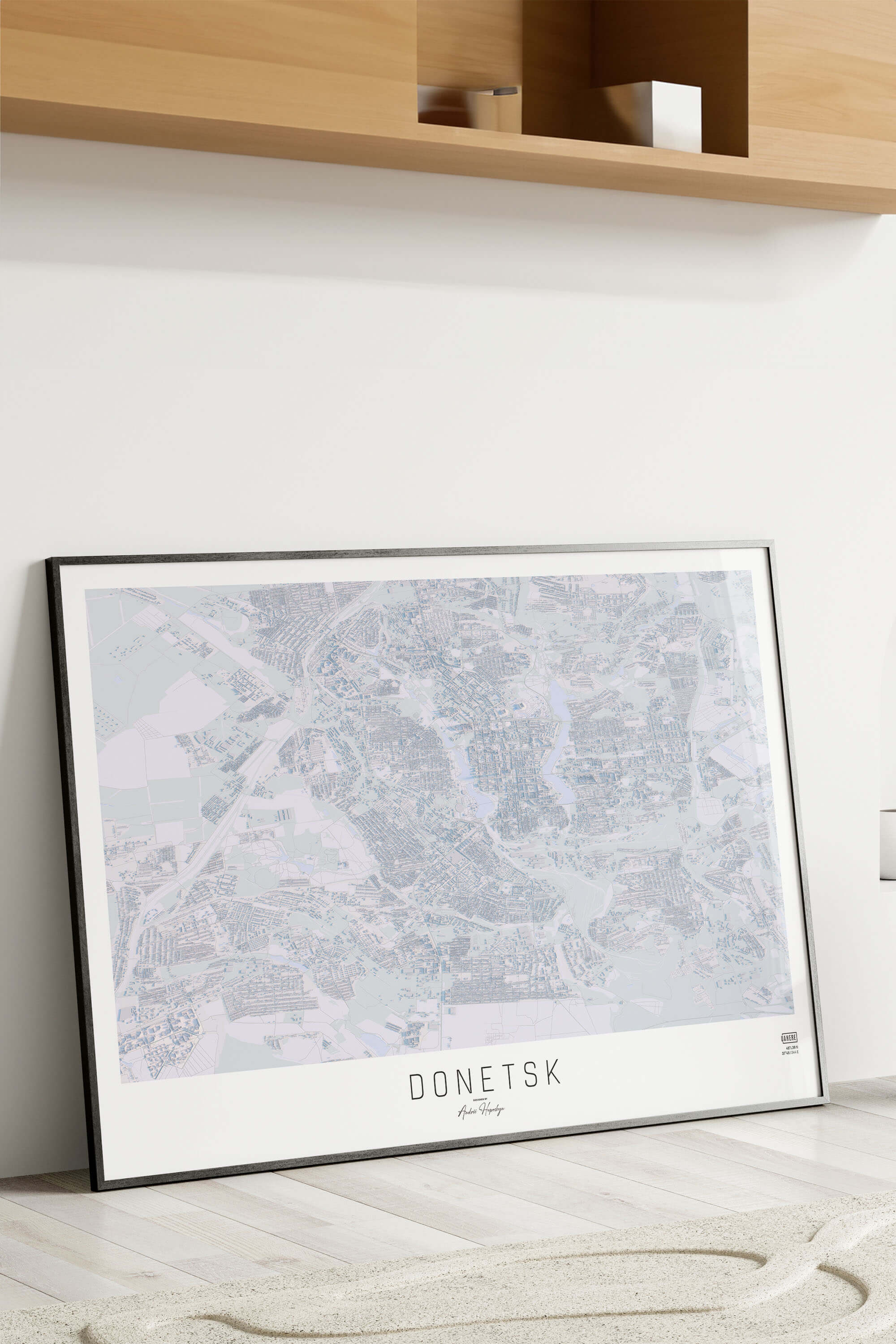 Картина міста Донецьк в рамці на фоні стіни
